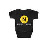 Baby Classic Subway Logo Romper | Black romper with a blue circle featuring a white "N". Text below reads: "Brooklyn to Queens." Perfect for fans of the NYC Subway Line.